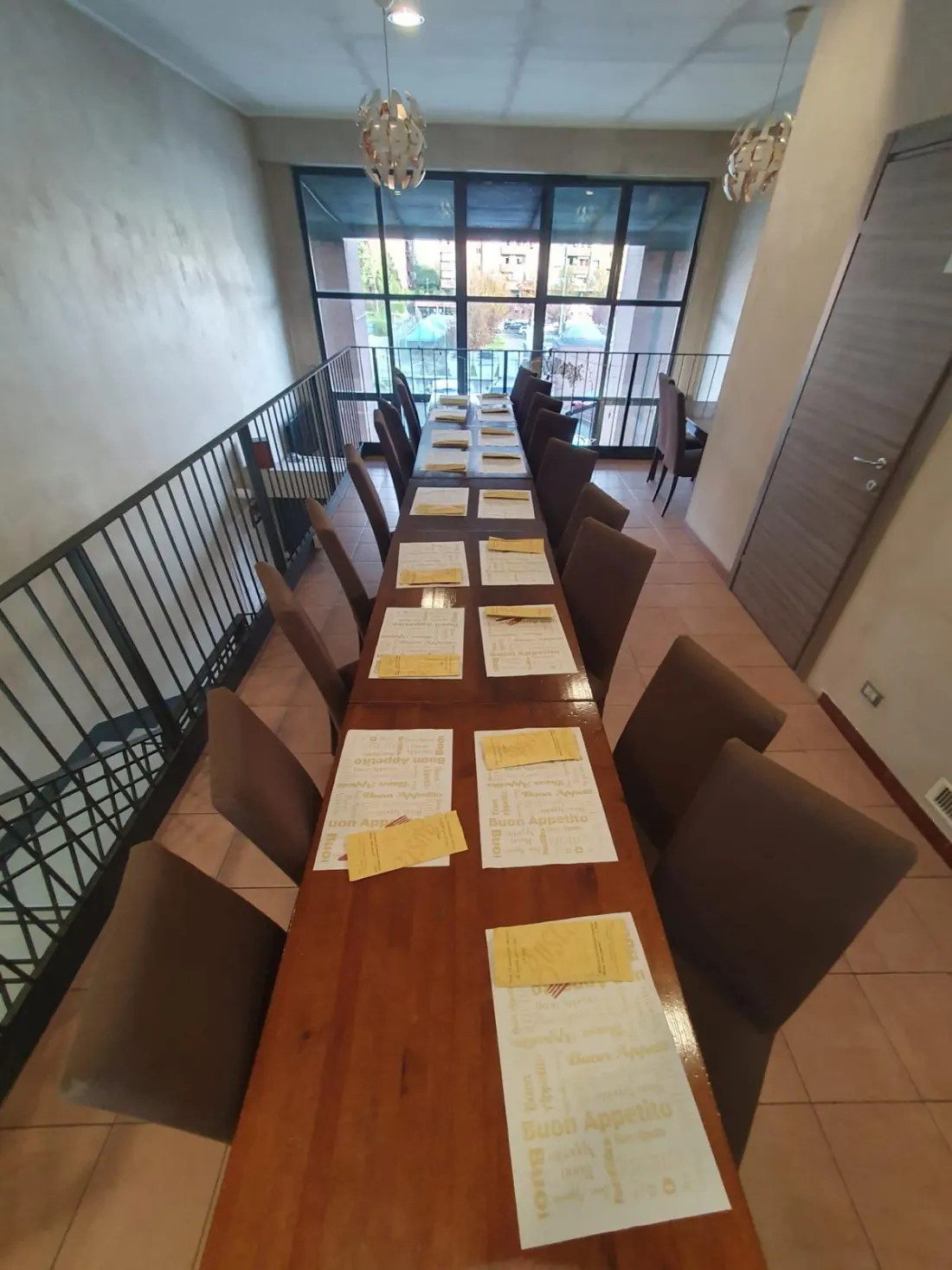 Il tavolone del piano di sopra apparecchiato, affacciato sulle vetrate